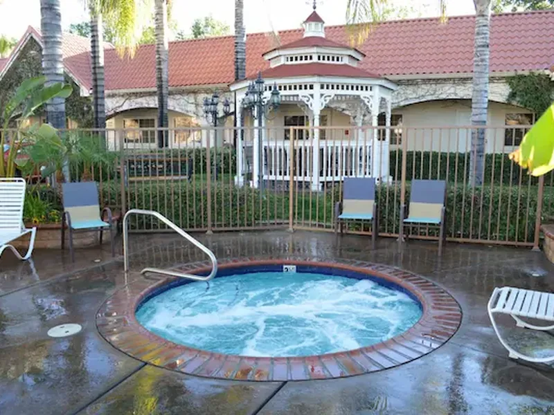 Outdoor hot tub surrounded by landscaping.